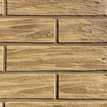 Textured tan brick wall with a wood grain pattern.
