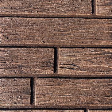 Close-up of textured brown brick wall.