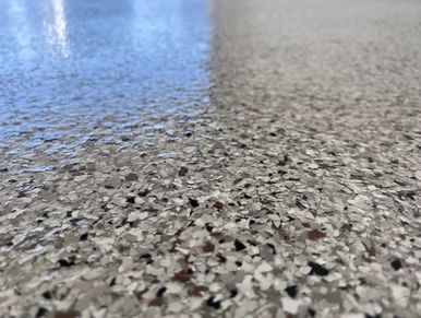 Close-up of a speckled, polished floor surface with reflective shine.