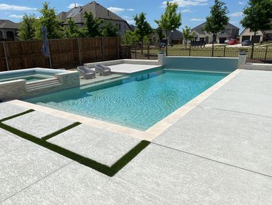 Modern backyard swimming pool with seating and clear water.