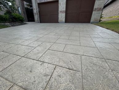Concrete driveway with two brown garage doors.