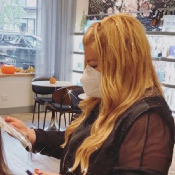 Our salon owner, Lisa, cutting hair in her mask following protocols.