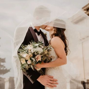 A bride and groom share a kiss at a wedding 