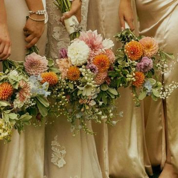 Bridesmaids holding colorful bouquets.