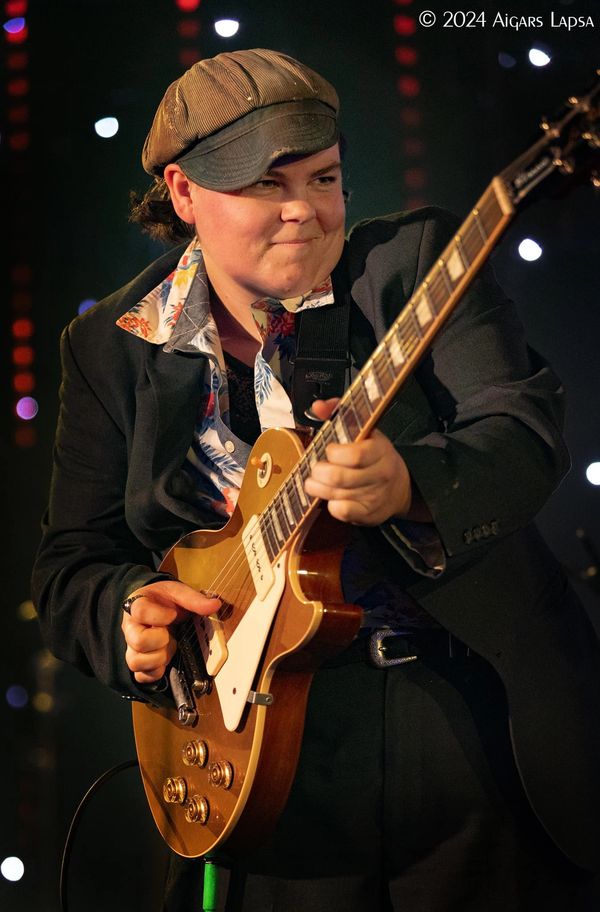 Musician passionately playing an electric guitar on stage.