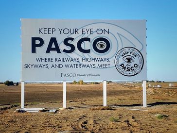Large wood mounted sign that says "Keep Your Eye on Pasco"