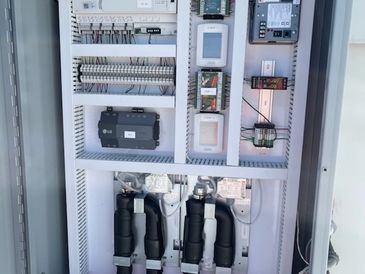 Open electrical control panel with various components and wiring.