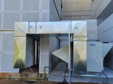 Industrial ventilation system with metal ducts outside a building.