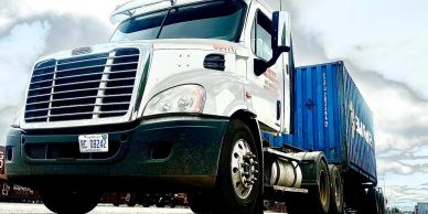 White semi-truck with blue shipping container.