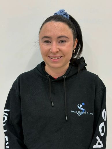 Woman smiling in black sports club hoodie.