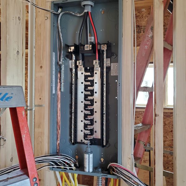 Open electrical panel in a wooden framed construction site.