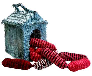 A crocheted gray doghouse with red crocheted sausages spilling out.