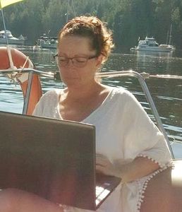 Brentwood Bay, BC. Lesley Porterfield, counsellor, working on her computer on her sailboat.