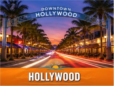 Downtown Hollywood street at sunset with palm trees and lights.