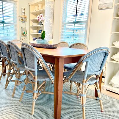 A dining area staged at the beach by Nest + Feather Home Staging and Design Studio 