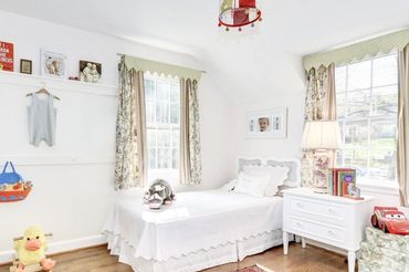 Children's bedroom professionally designed and home staged w/ accent wall highlighting books & toys  