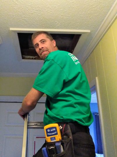 Inspector Damon on a ladder at an attic entry