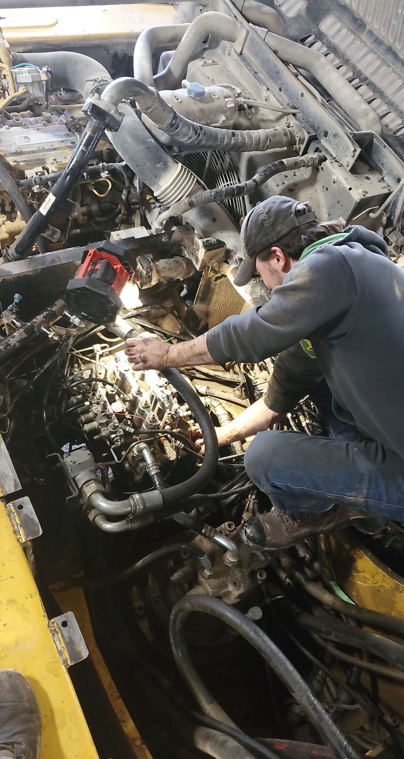 James working on a John Deere 350 - hydraulic leaks.