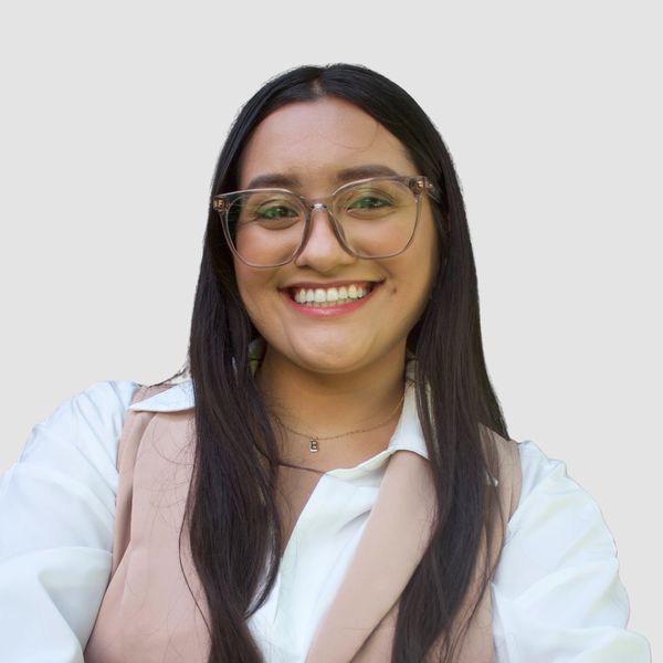 Smiling woman wearing glasses and formal attire.
