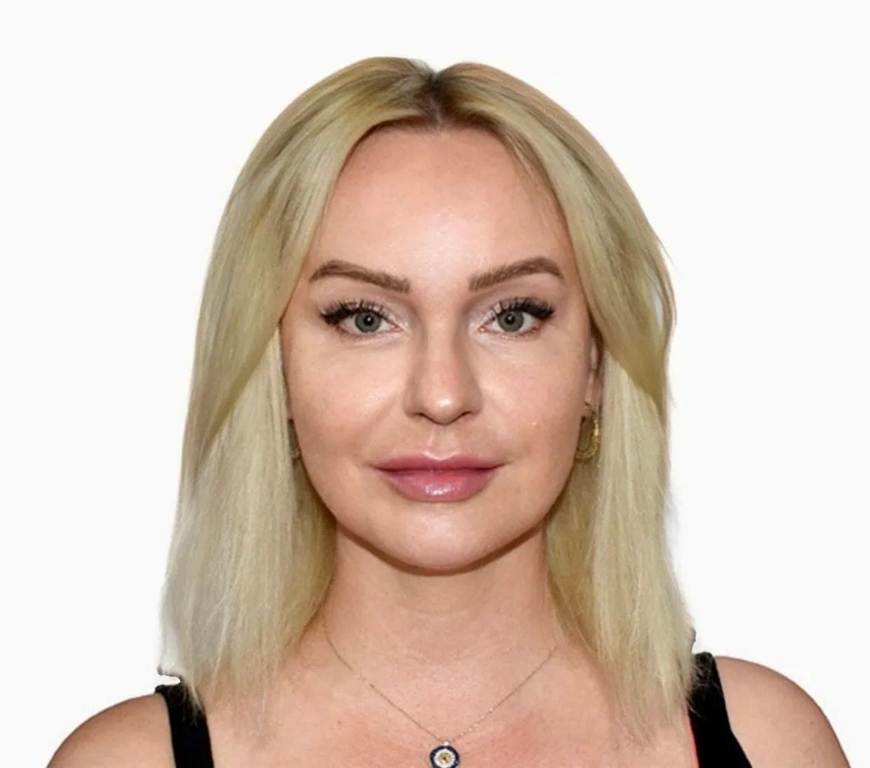 Blonde woman with green eyes and light makeup.