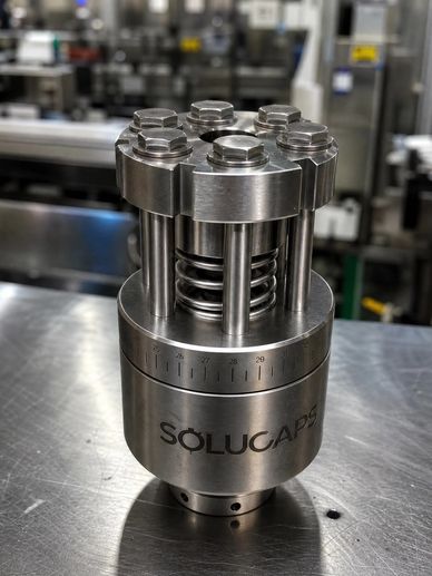 Close-up of a metallic Solucaps industrial component with bolts and springs.