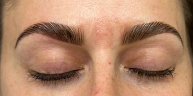 Close-up of well-groomed eyebrows and closed eyes.
