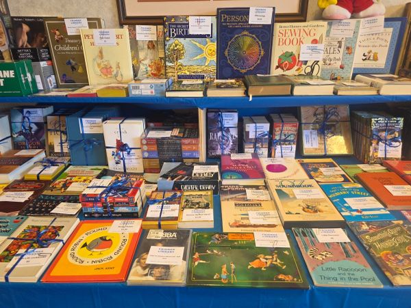 Books displayed on a table at a sale or event.