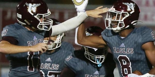 High school football players celebrating a successful play during a game.