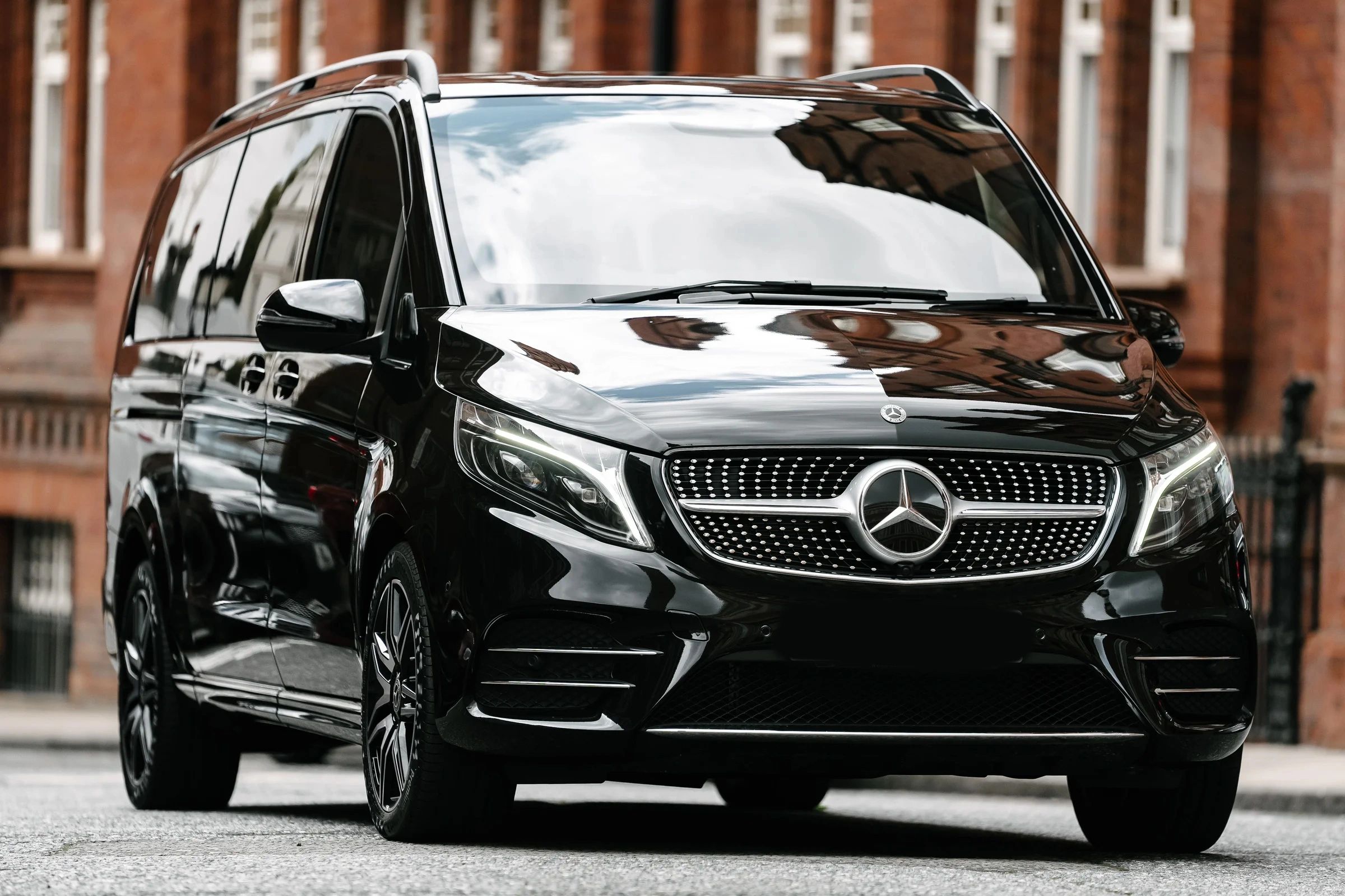 Sleek black Mercedes-Benz van parked on a city street.