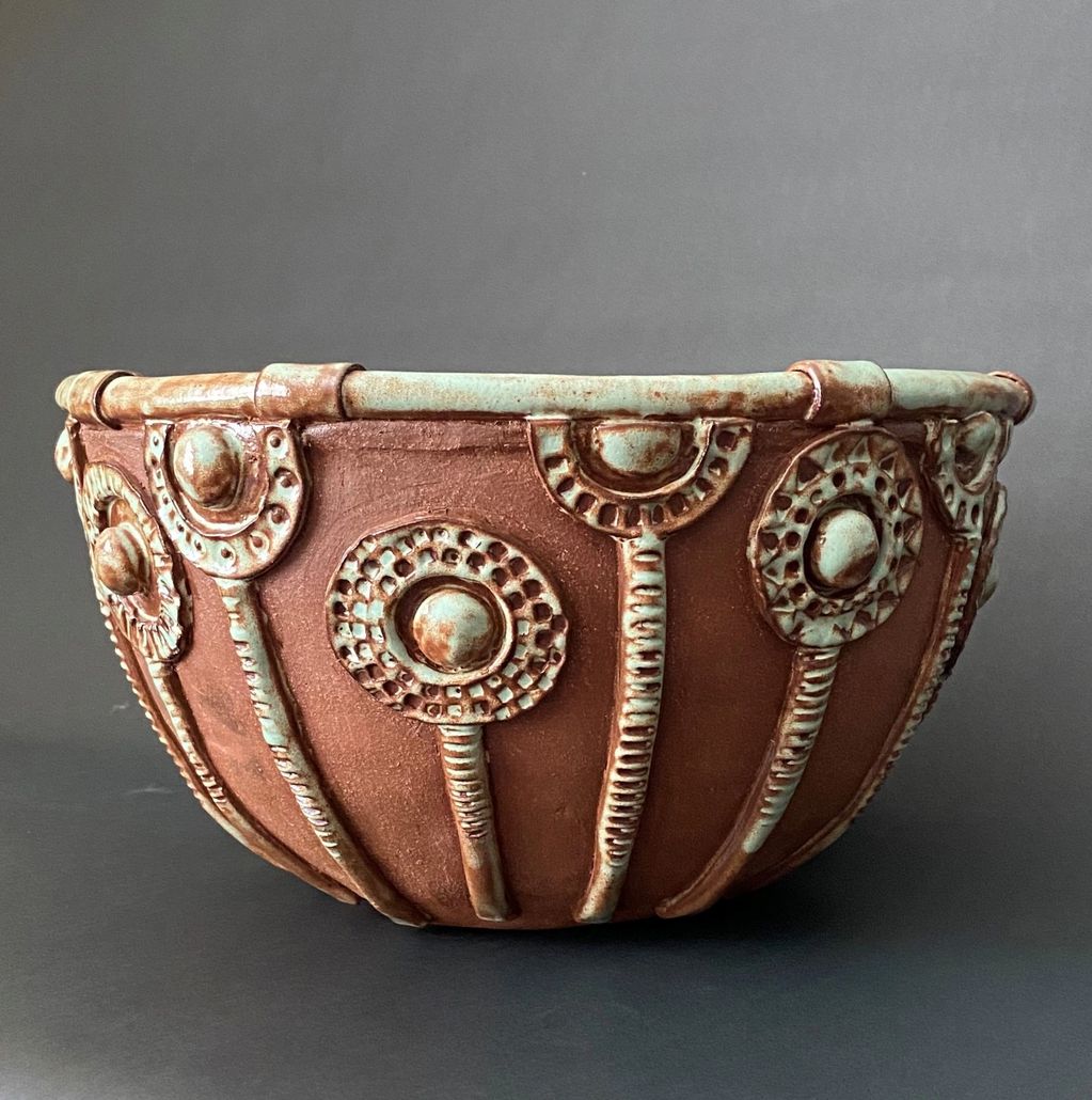 Marigold Bowl. Large, hand-built bowl with relief marigold design. Moonbeam green glaze over bare, r