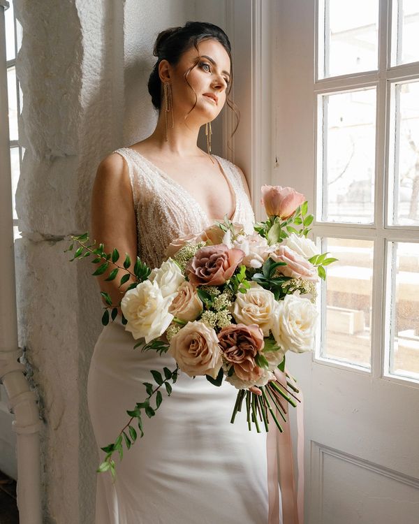 Mariée avec son bouquet de fleurs naturelles avec Roses tons de blush crème et vert. Fleuriste Laval
