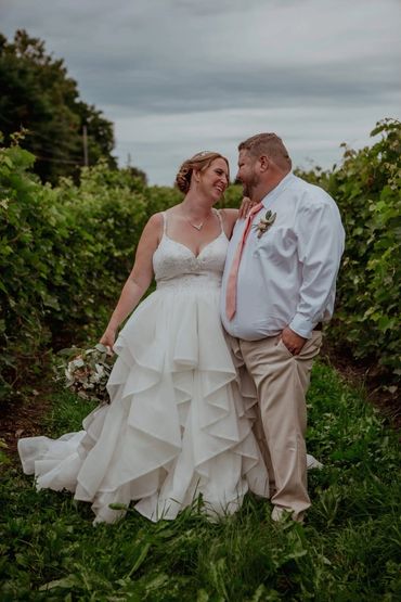 Couple de nouveaux mariés dans vignoble à St-Eustache avec bouquet et boutonniere fleurs fraîches