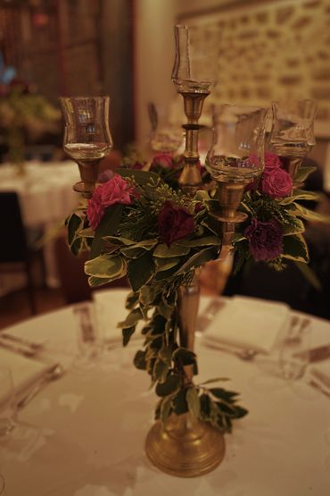Centre de table de fleurs naturelles sur chandeliers dorés pour mariage romantique et chic  Montreal