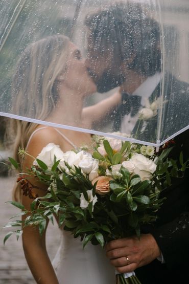 Couple s'embrassant avec bouquet de mariée romantique de Dahlias et Roses à un mariage à Montreal
