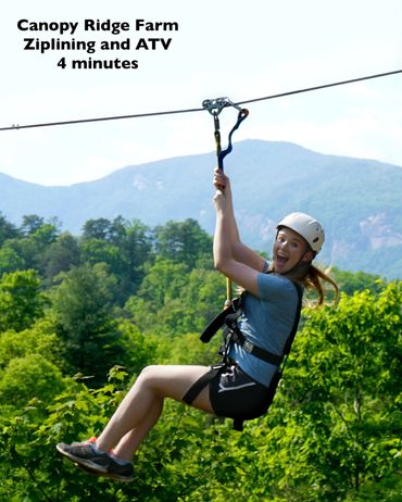 A joyful woman ziplining over lush green forest with mountains in the background.