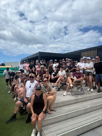 Group photo of people outdoors under a cloudy sky.