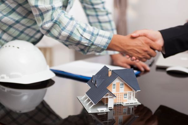 Handshake over house model, contract.