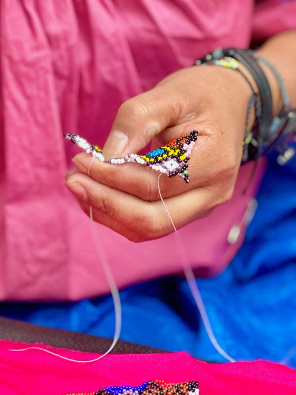 Hand crafting colorful beaded art with thread and needle.