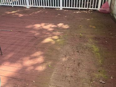 A wooden deck with a dirty, mossy section on one side.