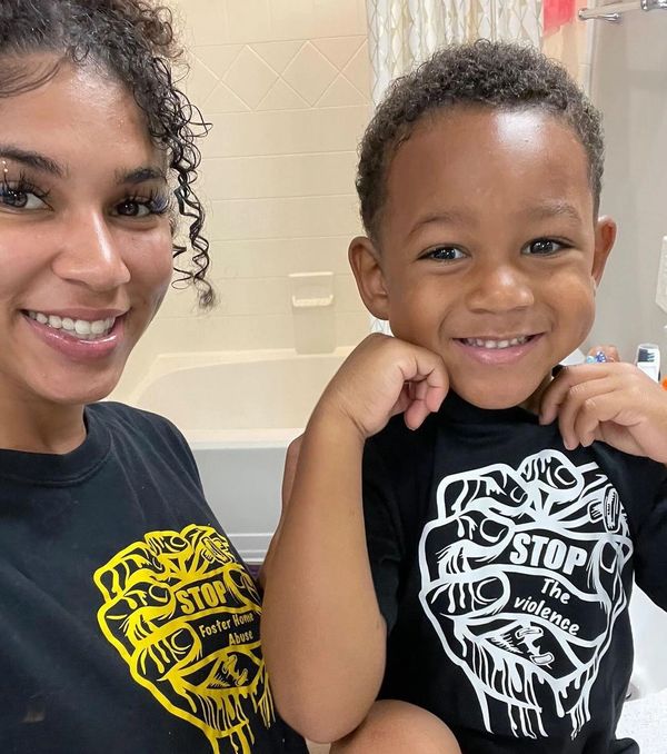 Smiling woman and child wearing matching shirts with anti-violence messages.