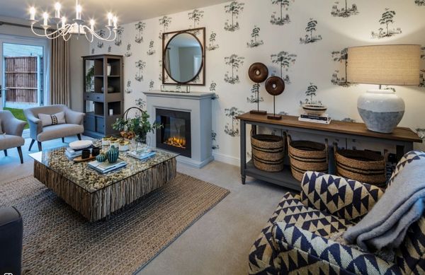 Cozy new build living room with patterned wallpaper, fireplace, and rustic coffee table.