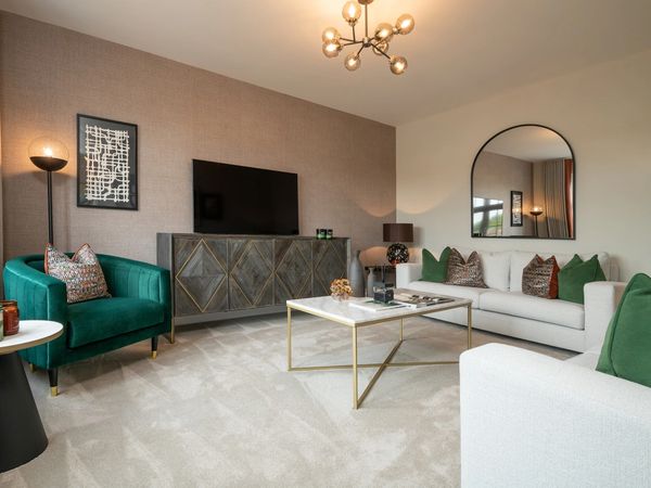 Elegant new build living room with green accent chairs, neutral sofa, and modern gold coffee table.