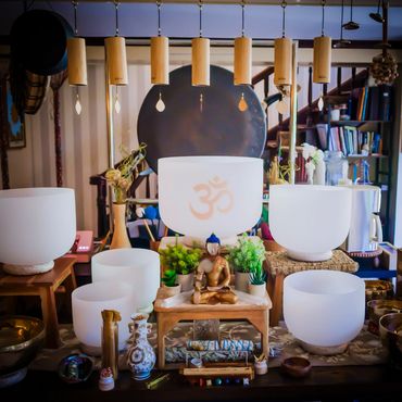 A collection of white crystal singing bowls with the Buddah.