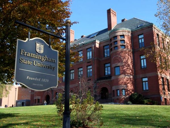 Framingham State University sign in front of a historic red brick campus building.