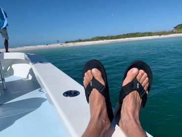 A person wearing black sandals on a yacht