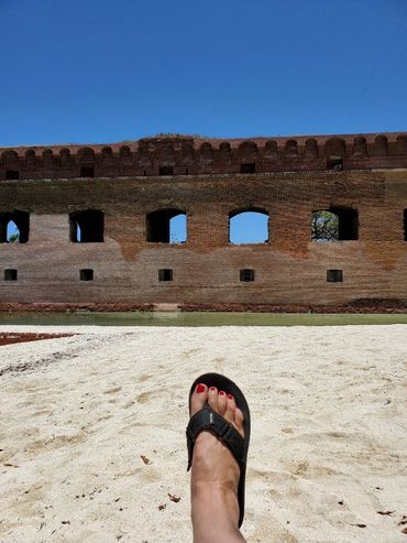 woman wearing black sandal on the sand