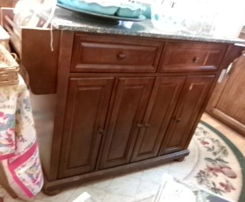 Wooden kitchen cabinet with drawers and doors.