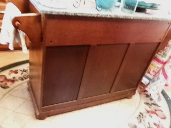 Wooden kitchen island on a carpet with floral patterns.