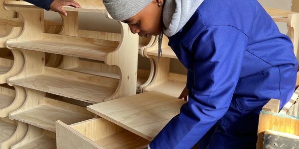 Person inspecting wooden furniture drawers.