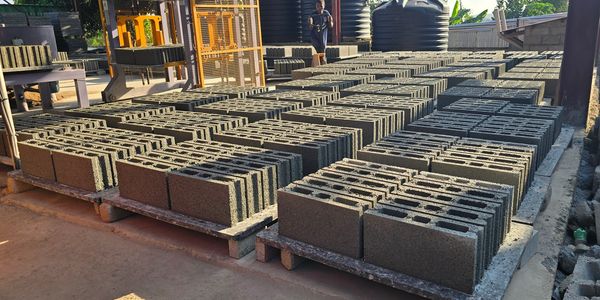 Rows of freshly made concrete blocks at a manufacturing site.